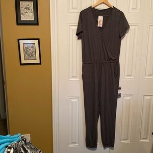 NWT jumpsuit in gray, size large. Pockets and snap at v neck.